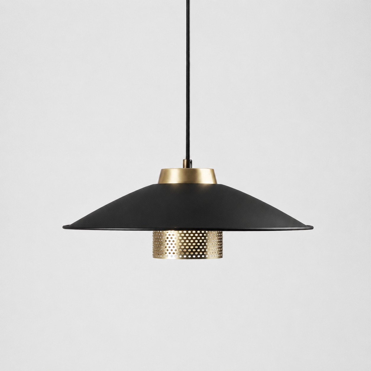 Black and antique brass metal pendant light with wide conical shade on a white background